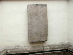 Stadtkirche-Chor von Südostenen-Grabstein aus dem aufgelassenen Kirchhof-Umschrift schwer leserlich-Zentralteil startk verwittert