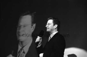 FDP: Wahlkampfveranstaltung zur Landtagswahl: Schulzentrum Am Heimgarten, Forum: FDP-Generalsekretär Guido Westerwelle bei Ansprache mit Mikrofon: dahinter Großübertragung auf Leinwand: 18. Februar 2000