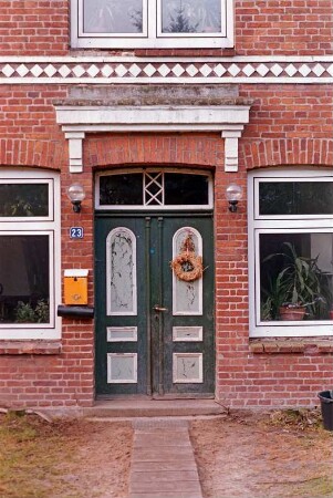 Hörn 23: Hofanlage: traufständiges Bauernhaus aus Backstein von 1874: Straßenfront, Detailaufnahme: Eingangstür mit Oberlicht, darüber Verdachung, Gesims, Hausnummer