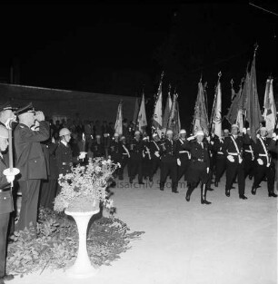 Haarmann, Wennemar: Verabschiedung: Rolfshagener Kupfermühle: Großer Zapfenstreich der Kreisfeuerwehr: Fahnenträger marschieren, links salutierende Feuerwehrleute, im Hintergrund Gäste