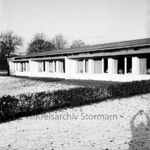 Rade: Grund- und Hauptschule: Rader Weg: vorn Rasen mit Hecke: hinten Klassentrakt: hinten links Bäume: Winter
