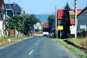 Blick entlang der abschüssigen Dorfstraße, Häuser