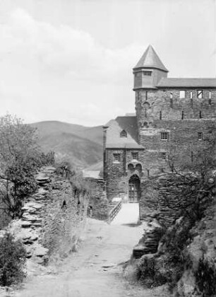 Blick von der Vorburg auf den Haupteingang von Burg Stahleck mit fertiggestelltem Ecktürmchen und Wehrgang der Schildmauer
