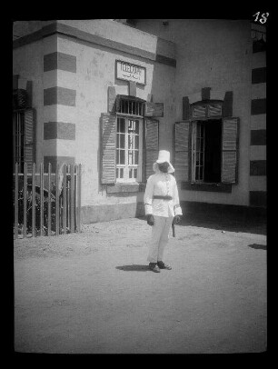 Zagazig (Ägypten): Poststation (oder Bahnhof (?)) mit farblich abgesetzten Simsen und Wandkanten, davor ein Ordnungshüter in weißer Uniform