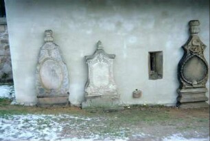 3 Grabsteine an der Südfront der Kirche an der Sakristei, dazwischen Piscina