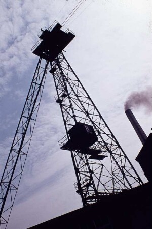 Oelsnitz, Albert-Funk-Schächte : Oelsnitz, Albert-Funk-Schächte (bis 1949 Vereinsglück-Schächte) II (links) und I des VEB Steinkohlenwerk Deutschland in Oelsnitz (Erzgebirge). Kabelkrananlage zur Haldenbeschickung Betriebsabteilung Deutschland des VEB Steinkohlenwerk Deutschland in Oelsnitz (Erzgebirge), Maschinenturm (erbaut 1934, heute BEFA Fahrzeug- und Stahlbau GmbH)