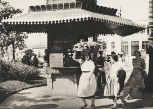 Lissabon. Portugal. Straßenszene. Zeitungskiosk. davor eine Portugiesin die ihre Last auf dem Kopf trägt