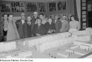 Ausstellungsbesucher während der Erklärung des Architekturmodells der Stalinallee in Berlin