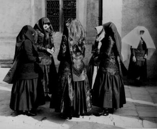 Wttichenau (Oberlausitz). Frauen und Mädchen stehen in sorbischer Festtagstracht vor einer katholischen Kirche
