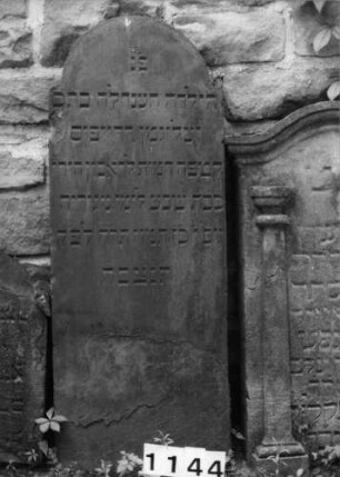 Grabstein 1144 (Index: 99630647) Material: Sandstein Zustand: unten abgeblättert Maße HxBxT: 128x48x7 cm Beschreibung: Stele mit eingezogenem Rundbogenabschluß: Grabstein 1144