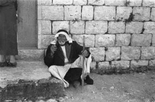 Reisefotos Mittelmeer. Vor einem Hauseingang sitzender einheimischer Mann im arabischen Raum