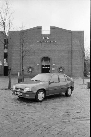 Vorstellung des Opel Kadett GSi 16 V: auf Parkplatz Bahnhofstraße, Ahrensburg: hinten Parkhaus "Alter Lokschuppen"