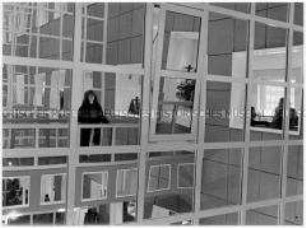 Junge Frau spiegelt sich in Häuserfassade (Altersgruppe 14-17)