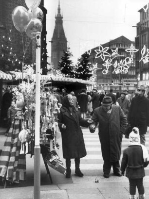 Hamburg-Altstadt. Trubel auf einem Weihnachtsmarkt in der Mönckebergstraße. Im Hintergrund der Turm des Rathauses der Freien- und Hansestadt Hamburg