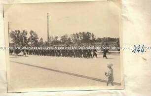 Männer in Sportbekleidung in Formation auf einer Straße