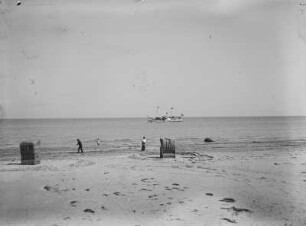 Blick auf die Ostsee mit Dampfer und Urlaubern am Strand