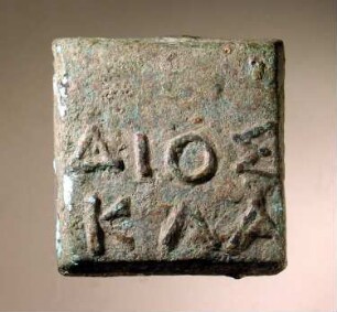 Einstufiges quadratisches Gewicht mit griechischer Inschrift: ΔΙΟΣ / ΚΛΑ