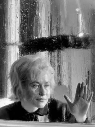 Bienenbüttel. Adventszeit. Eine Frau durch ein verregnetes Fenster