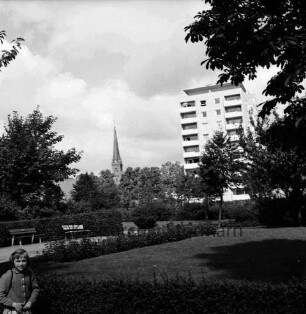 Kurpark: Hecken, Blumenrabatten und Bänke: hinten rechts Hochhaus "Liebe" an Kurparkallee: hinten Mitte Turm der Peter-Paul-Kirche: vorn rechts Mädchen