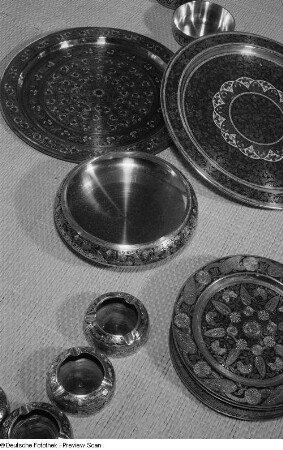 Mit floralem Ornament geschmücktes Geschirr und Aschenbecher aus Metall auf der Leipziger Herbstmesse 1954