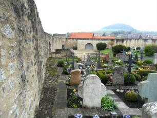 St Michael-Kirchhof nach Westsüdwest mit Kirchhofmauer im Verlauf (Werkstein im Mauersteinverband) und Rundturm