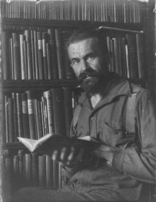 Rudolf Zimmermann : Portrait von Rudolf Zimmermann vor einem Bücherregal.