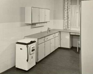 Anbauküche : Leipzig. Herbstmesse der Möbelindustrie der DDR, 1956. Anbauküche (1956; VEB Küchenmöbel Radeberg) und Waschmaschine in Ausstellungskoje