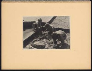 Jungen spielen mit Sand und Wasser