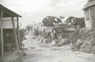 Reisefotos. Dorfstraße mit Hütten (wahrscheinlich auf Haiti)