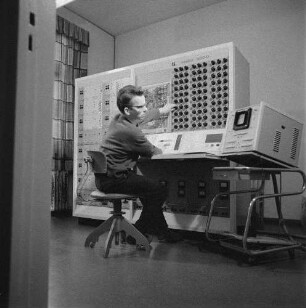 Elektronischer Analogrechner. Mitarbeiter, auf einem Drehstuhl sitzend, bei Arbeiten an der Hardware : Dresden-Klotzsche. Elektronischer Analogrechner. Mitarbeiter, auf einem Drehstuhl sitzend, bei Arbeiten an der Hardware