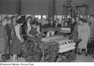 Messebesucher sowie zwei Chinesinnen, die eine Maschine der Textilindustrie vorführen (Halle E), Technische Messe 1953