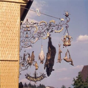 Schmiedeeisener Ausleger mit Jagdtrophäen an einer Odenwälder Gaststätte