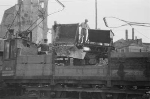 Dresden-Neustadt, Hauptstraße. Enttrümmerung mit Straßenbahn-Gütertriebwagen und Feldbahn, deren Muldenkipploren über ein provisorisch aufgeständertes Gleis in Schütthöhe gefahren werden