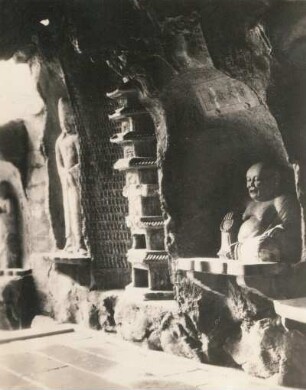 China. Tempelhöhle der 1000 Mandarins bei Hangzhou. Inneres mit Standfigur und sitzendem Buddha