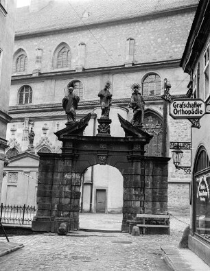 Schwarzes Tor mit einer Skulpturengruppe an der Kirche Mariä Himmelfahrt