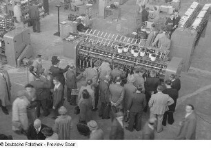 Besucher betrachten eine Textilmaschine, Technische Messe 1953