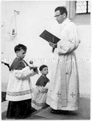 Priester mit zwei Messdienern
