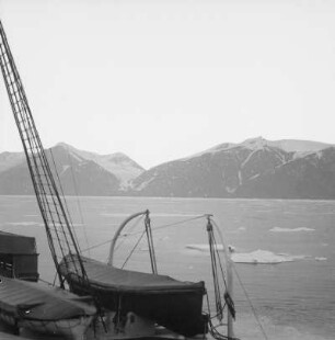 Norwegen. Blick von einem Passagierdampfer über einen Fjord mit Treibeis gegen Steilküste
