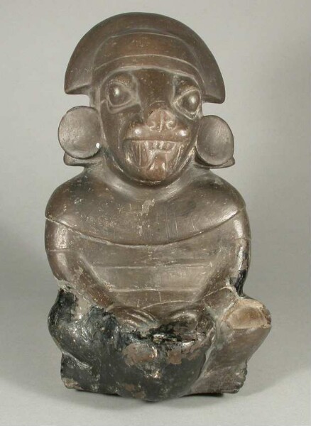 Sitzende anthropo-zoomorphe Figur mit Trommel