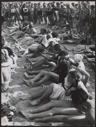 Zahlreiche Frauen sitzen am Strand