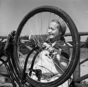 Arbeitsmaid des Reichsarbeitsdienstes bei der Fahrradpflege