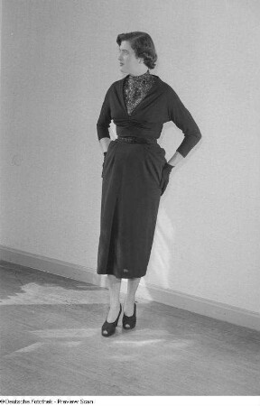 Eine Frau posiert mit Kleid und Handschuhen bei der "Internationalen Messemodenschau", Herbstmesse 1953