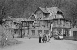 Eine Straßenszene mit Urlaubern. Im Hintergrund ein FDGB-Erholungsheim