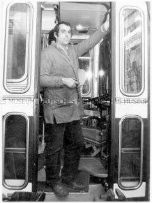 Straßenbahnfahrer in der Tür einer Straßenbahn (Altersgruppe 14-17)
