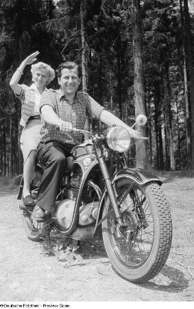 Ein Mann und eine Frau, auf einem Motorrad sitzend