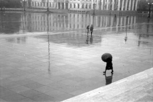 München: Königlicher Platz [Königsplatz], Spiegelung der Führerbauten, Frau mit Schirm