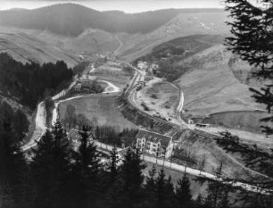 Talblick : Blick in ein Tal mit bewaldeten Berghängen, Straßen und Gebäuden