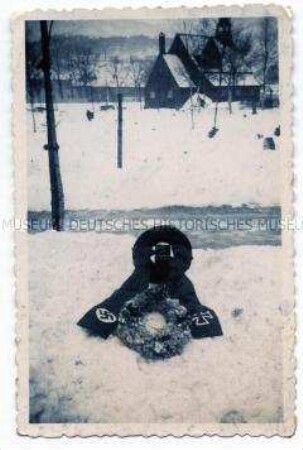 Soldatengrab mit Kränzen und Trauerschleife im Schnee