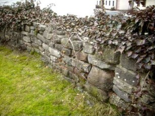 Kirchhof im Norden mit Resten der Kirchhofmauer im Verlauf
