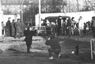 Menschen vor einem provisorischen Grenzübergang in der Schwedter Straße